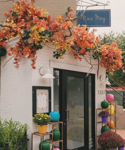 The exterior of Nina May with a fall flower arrangement draped above the front door. (Photo: Nina May/Instagram)