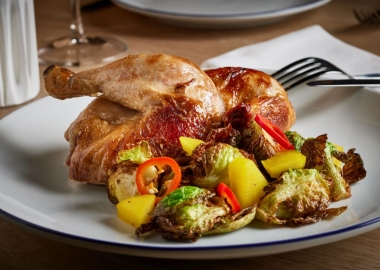 Rosedale's rotisserie, organic chicken with a salad on a white plate with a fork & knife beside it. (Photo: Greg Powers)