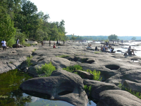 People sitting and sunbathing on the rocks on the north side of Belle Isle. (Photo: Wikipedia)