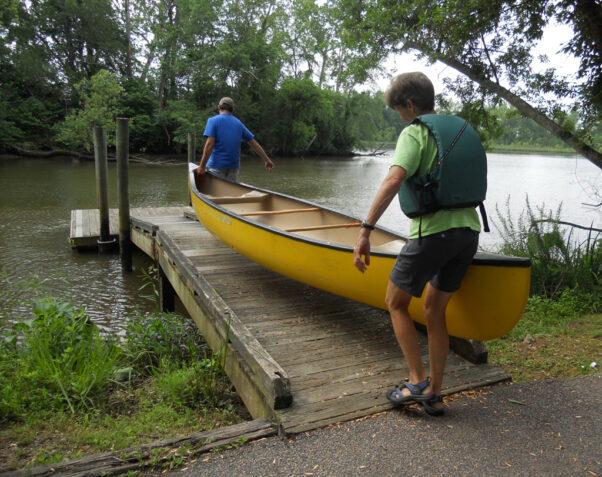 Two men carry a yellow and black canoe down the canoe launch at Deep Bottom Park. (Photo: Henrico County)