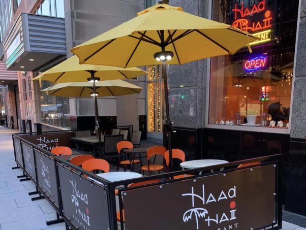 The exterior of Haad Thai with tables, orange chairs and yellow umbrellas fenced off in front. (Photo: Haad Thai/Facebook)ac