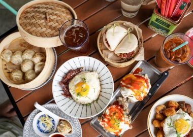 A wooden table filled with several dishes including dumplings and bao buns. (Photo: Hawkers Asian Street Food/Facebook)