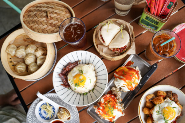 A wooden table filled with several dishes including dumplings and bao buns. (Photo: Hawkers Asian Street Food/Facebook)
