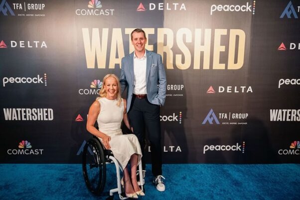 Mallory Weggeman in her wheelchair and husband Jay Snyder standing to her left in front of a poster for their movie Watershed in Los Angeles. (Photo: Mallory Weggemann/Facebook)