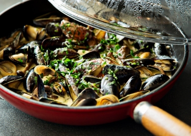 A red pan full of black mussels cooked in wine & lemon topped with parsley. (Photo: Mussel Bar/Facebook)