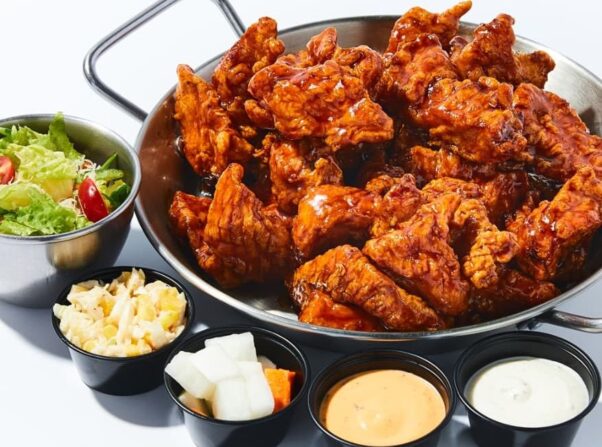 A wok full of Korean fried chicken from Pelican Chicken with four sauces and a side salad. (Photo: Pelicana Chicken/Instagram)