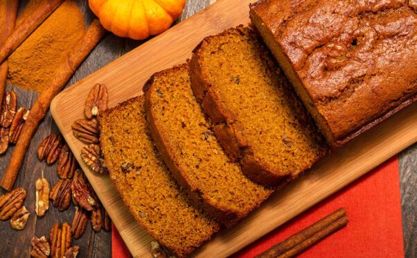 A loaf of pumpkin with 3 slices laying on a cutting board beside a pumpkin. (Photo: Contributed)