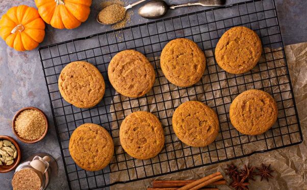 Eight pumpkin cookies laying on a colling rack beside 2 miniature pumpkins and spices. (Photo: Contributed)