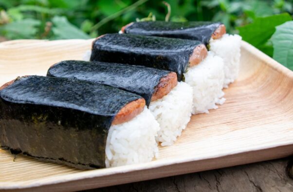 Four Spam musubi with rice and Spam wrapped in seaweed on a plate. (Photo: L&L Hawaiian Barbecue/Facebook)