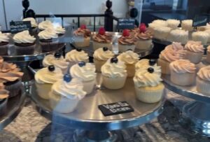 Round display stands of cupcakes iced in vanilla, chocolate and strawberry icing with cocoa beans and raspberries on top. (Photo: Alexandria Cupcake/Facebook)