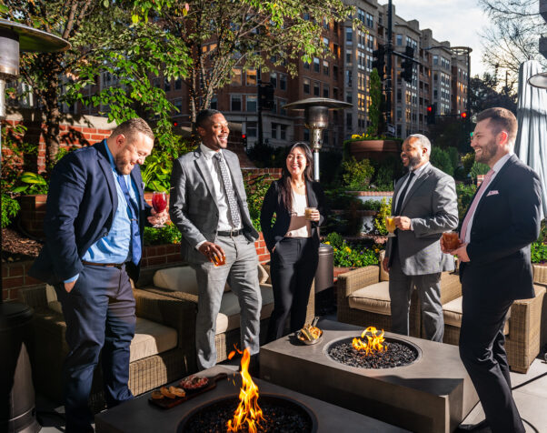 Four men in suits and a woman stand around a fire pit at Blue Duck Tavern. (Photo: Blue Duck Tavern)