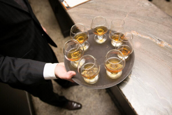 A man in a suit hold a tray of 7 cocktails in highball glasses. (Photo: Jack Rose Dining Saloon)