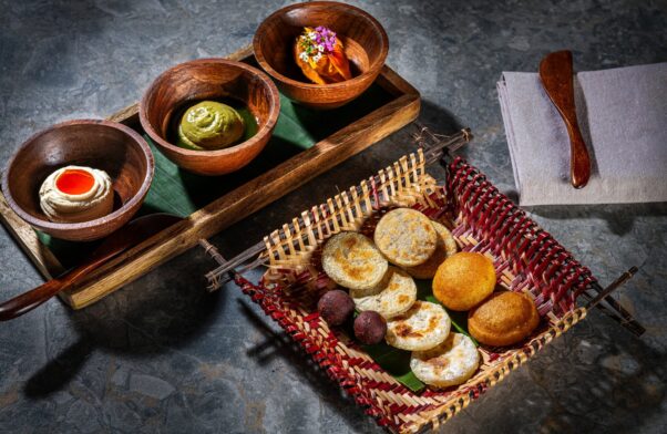 eight arepas in a basket with three dipping sauces. (Photo: Rey Lopez)