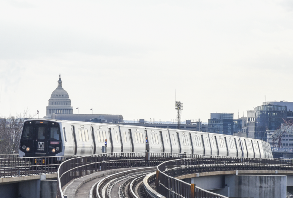 A Metro train runs on outside elevated track near National Airport with the Capitol Dome in the background. (Photo: WMATA)